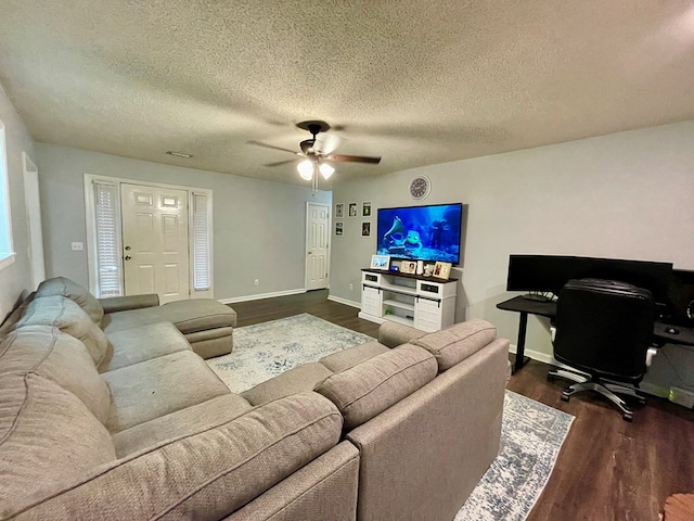 living room featuring ceiling fan, dark hardwood / wood-style flooring, and a textured ceiling