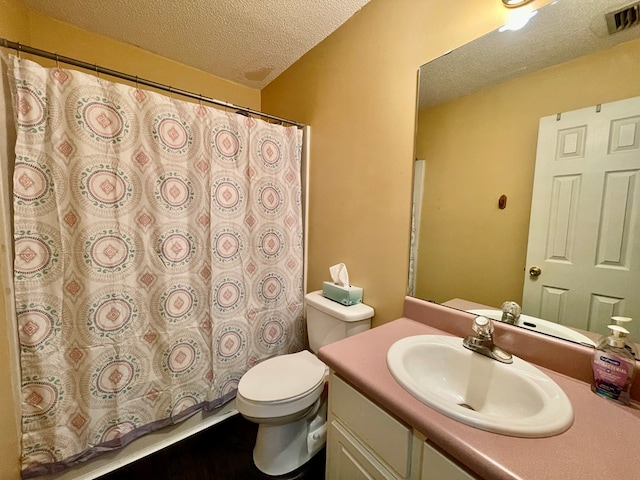 bathroom featuring vanity, a textured ceiling, and toilet