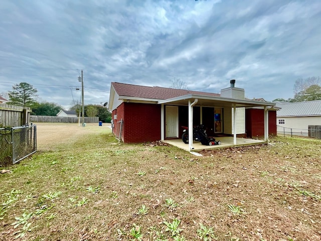 rear view of property featuring a patio area and a yard