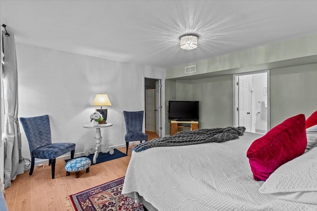 bedroom featuring hardwood / wood-style floors and ensuite bath