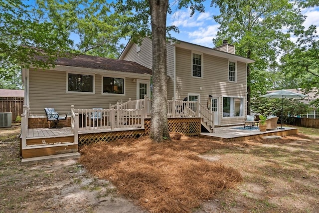 rear view of house with a deck and central AC unit