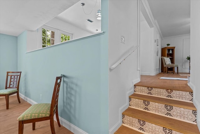 stairway featuring hardwood / wood-style flooring and ornamental molding