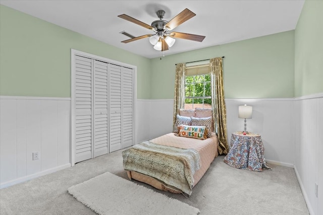 bedroom with ceiling fan, carpet, and a closet