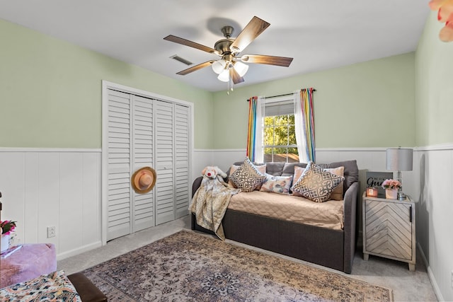 bedroom featuring ceiling fan, a closet, and light carpet