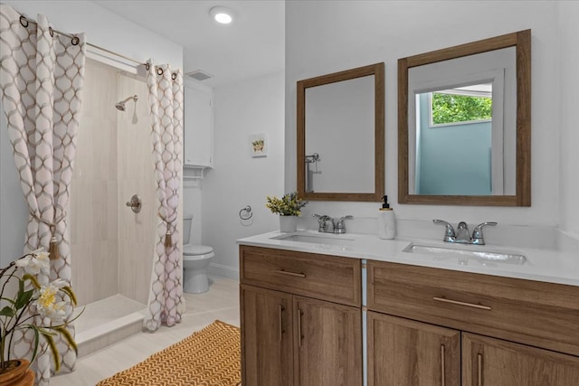 bathroom featuring toilet, tile patterned floors, vanity, and curtained shower