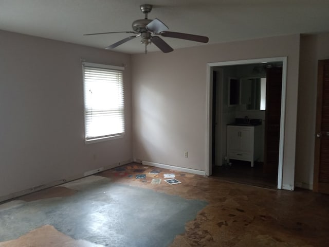 spare room with a sink, ceiling fan, and baseboards