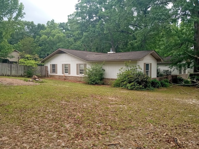 view of front of property featuring fence, a shingled roof, and a front yard