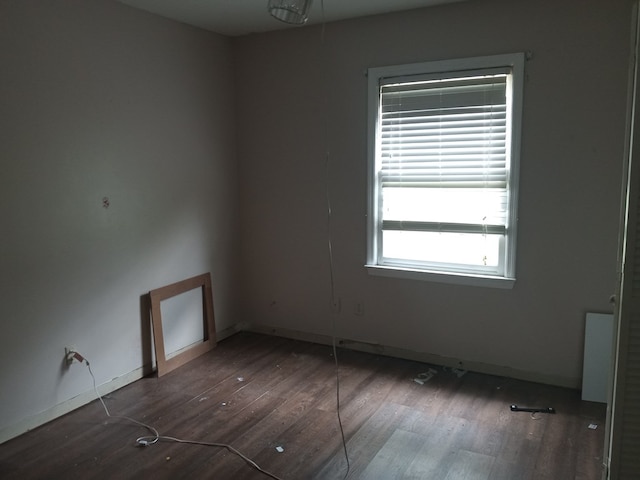 empty room featuring wood finished floors and baseboards
