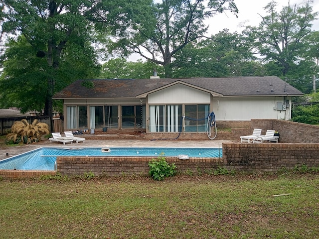 back of house with a fenced in pool, fence, a patio area, and a sunroom