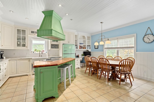 4 Woodmere Dr, Dothan, AL 36305 - kitchen featuring wooden counters, premium range hood, freestanding refrigerator, wainscoting, and light tile patterned floors