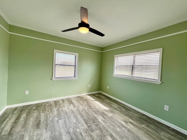 unfurnished room with ceiling fan, wood finished floors, and baseboards