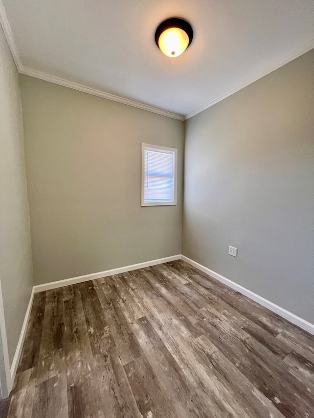 spare room featuring baseboards, wood finished floors, and ornamental molding