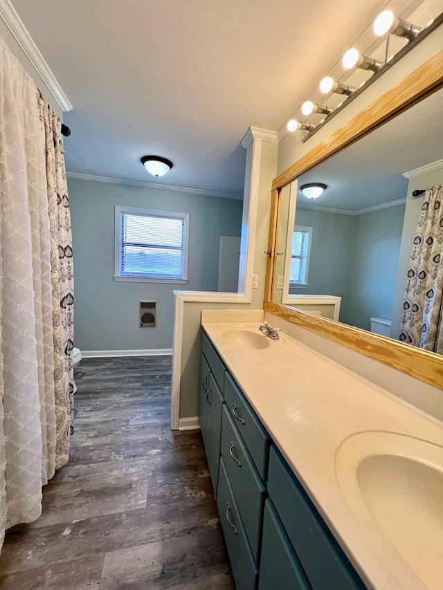 full bath featuring double vanity, ornamental molding, a sink, and wood finished floors