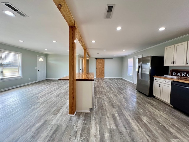 kitchen featuring a barn door, visible vents, white cabinets, open floor plan, and dishwasher