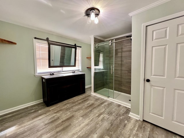 bathroom with crown molding, a stall shower, vanity, wood finished floors, and baseboards