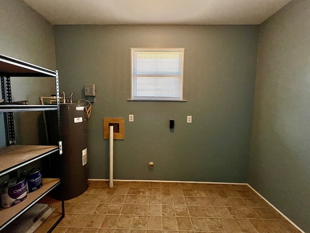 clothes washing area with laundry area, electric water heater, and baseboards