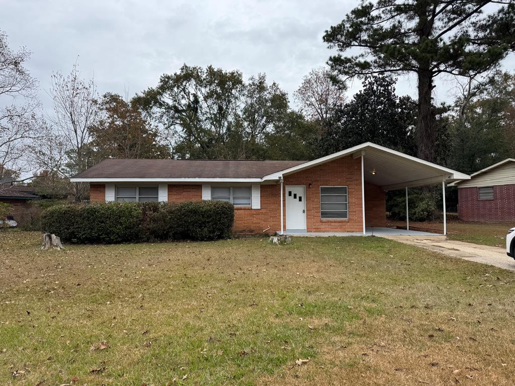 ranch-style house with a carport and a front lawn