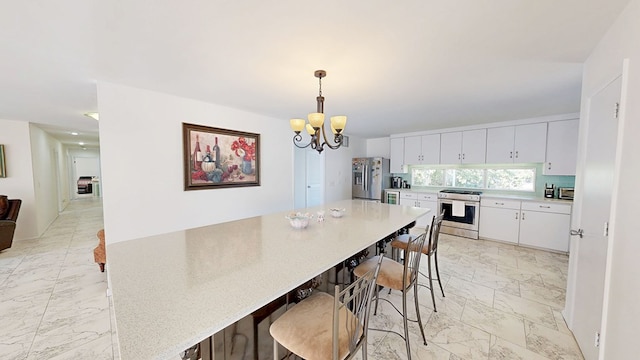 kitchen with white cabinets, appliances with stainless steel finishes, marble finish floor, light countertops, and a chandelier