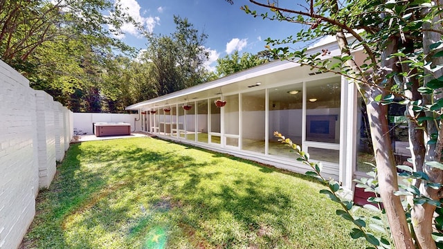 view of yard featuring a hot tub and a fenced backyard