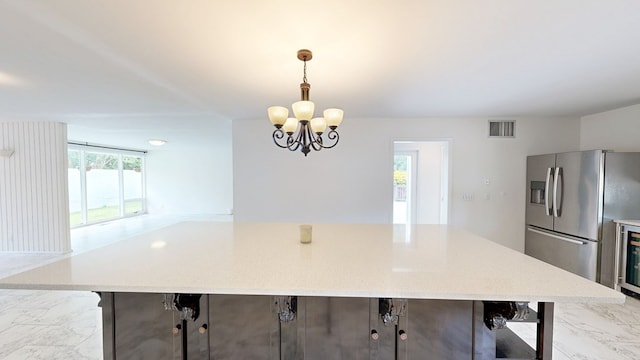 dining area with marble finish floor, a notable chandelier, visible vents, and beverage cooler