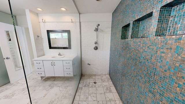 bathroom featuring tiled shower, vanity, and recessed lighting