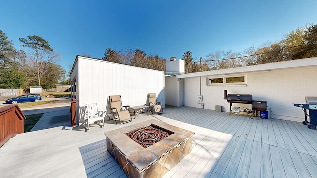 deck featuring a fire pit and area for grilling