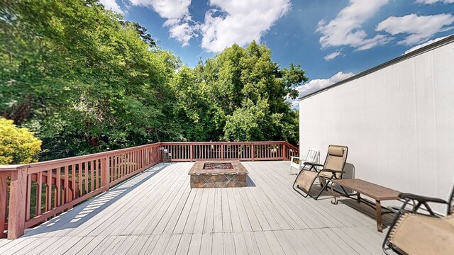 wooden terrace featuring an outdoor fire pit