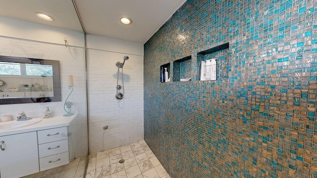 full bathroom featuring recessed lighting, tiled shower, tile walls, and vanity