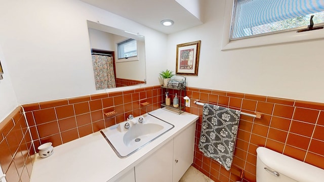 full bathroom with tile walls, recessed lighting, toilet, wainscoting, and vanity