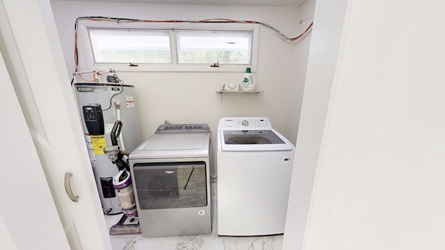 laundry room featuring marble finish floor, laundry area, separate washer and dryer, and electric water heater