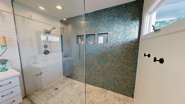 bathroom featuring marble finish floor, walk in shower, a wealth of natural light, and recessed lighting