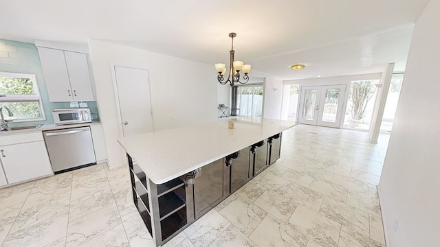 kitchen with dishwasher, light countertops, a sink, and white microwave