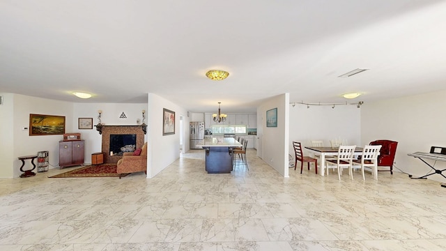 interior space featuring marble finish floor, a fireplace, and a chandelier