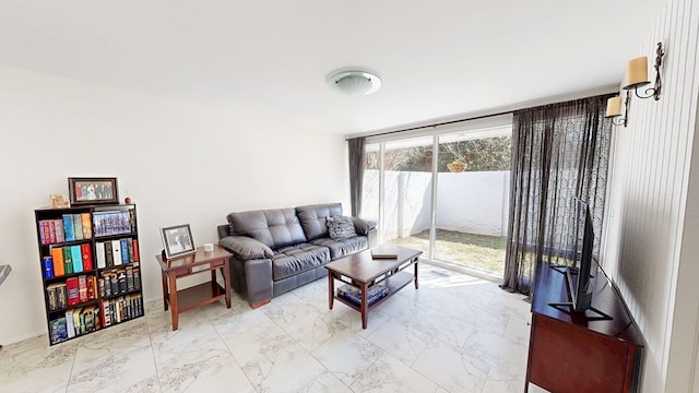 living area featuring marble finish floor and a wall of windows