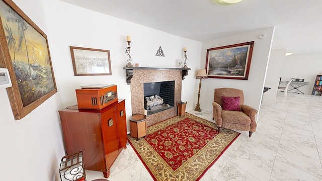 living area featuring marble finish floor and a fireplace