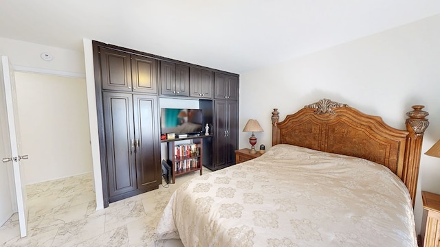 bedroom with marble finish floor and a closet