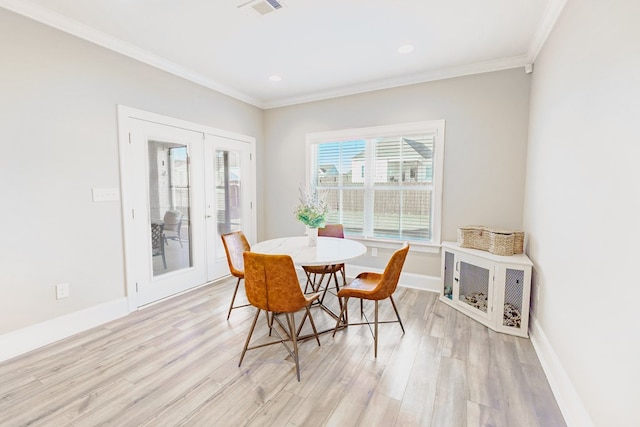 dining room with french doors, light hardwood / wood-style floors, and ornamental molding