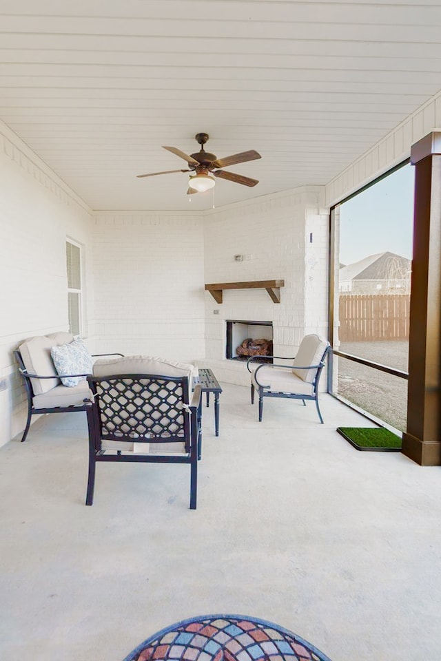 sunroom / solarium featuring ceiling fan and an outdoor fireplace