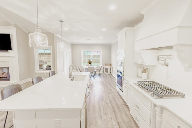 kitchen with a breakfast bar, a kitchen island with sink, and appliances with stainless steel finishes