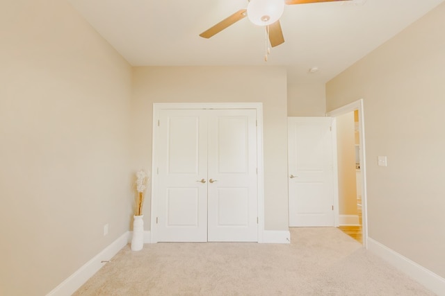 unfurnished bedroom with ceiling fan, light colored carpet, and a closet