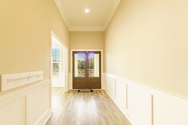 doorway featuring crown molding, french doors, and light wood-type flooring