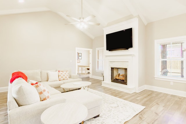 living room featuring ceiling fan, light wood-type flooring, and high vaulted ceiling