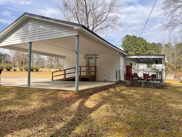 rear view of house featuring a carport and a lawn