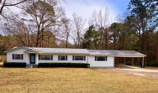 ranch-style house featuring metal roof, concrete driveway, a front lawn, and a carport