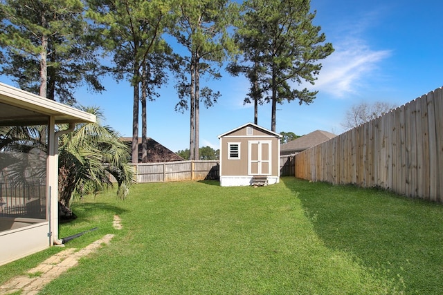 view of yard featuring an outbuilding, a fenced backyard, and a storage shed