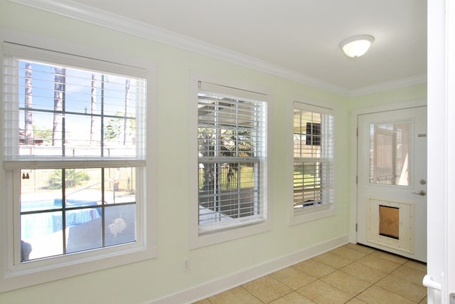 doorway to outside featuring baseboards, light tile patterned flooring, and crown molding