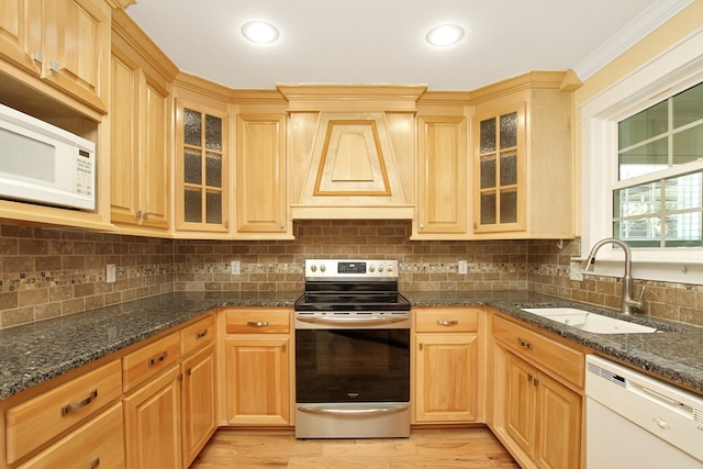 kitchen featuring white appliances, a sink, crown molding, light wood-style floors, and backsplash