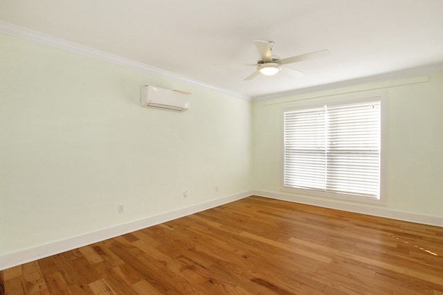 spare room with ornamental molding, an AC wall unit, baseboards, and light wood finished floors