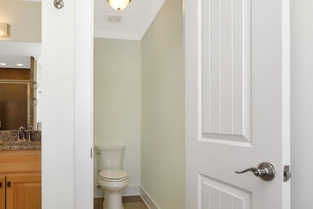 bathroom featuring baseboards, visible vents, toilet, ornamental molding, and vanity