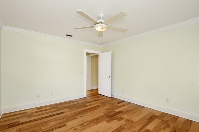 empty room featuring a ceiling fan, baseboards, visible vents, light wood finished floors, and crown molding